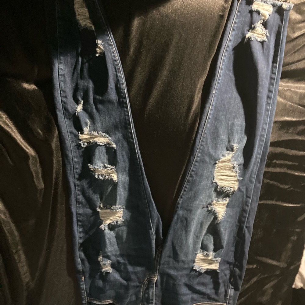 Dark blue ripped jeans.